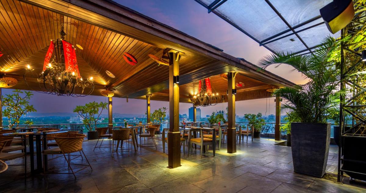 a restaurant with tables and chairs and lights at O Hotel Pune in Pune