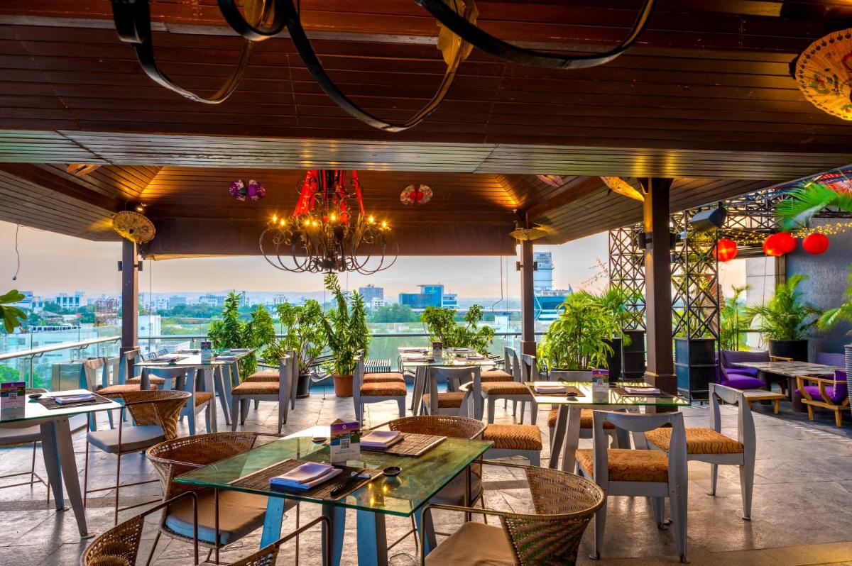 a restaurant with tables and chairs and a view at O Hotel Pune in Pune