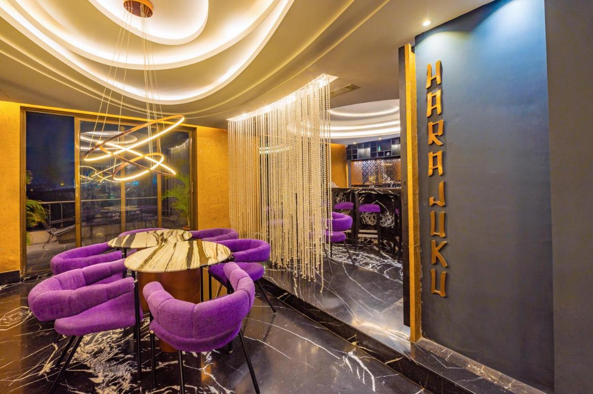 a dining room with purple chairs and a table at O Hotel Pune in Pune