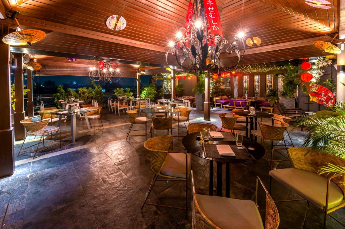 a restaurant with tables and chairs in a room at O Hotel Pune in Pune