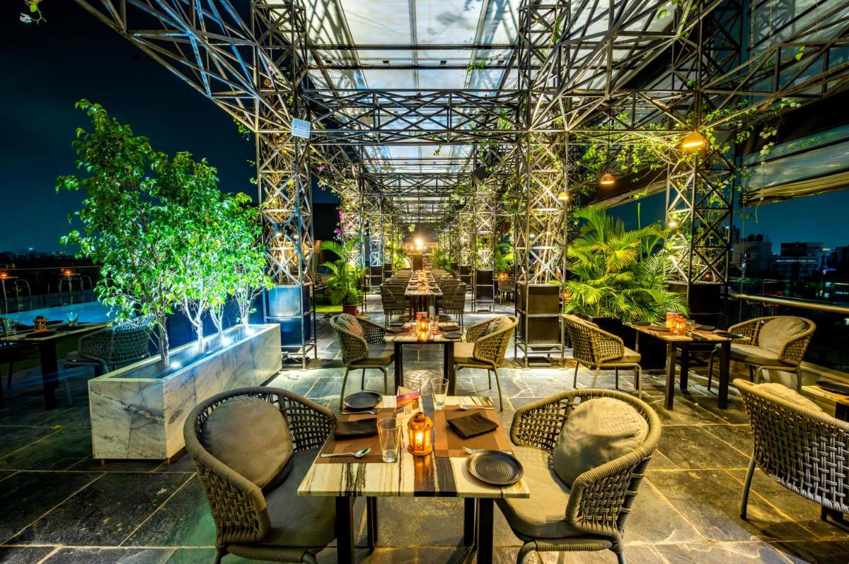 a view of a restaurant with tables and chairs at O Hotel Pune in Pune