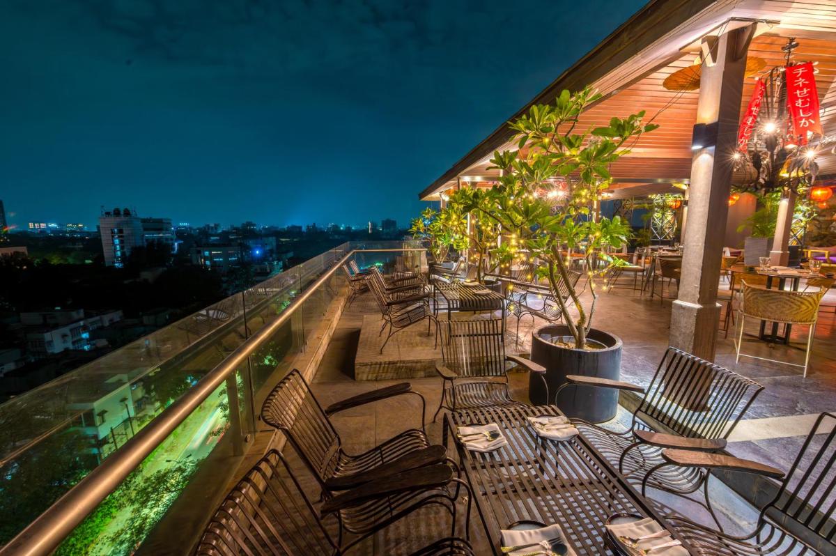 a balcony with chairs and tables on a building at O Hotel Pune in Pune