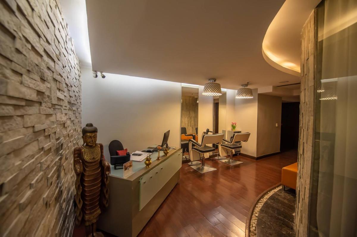 an office with a stone wall and a desk and chairs at O Hotel Pune in Pune
