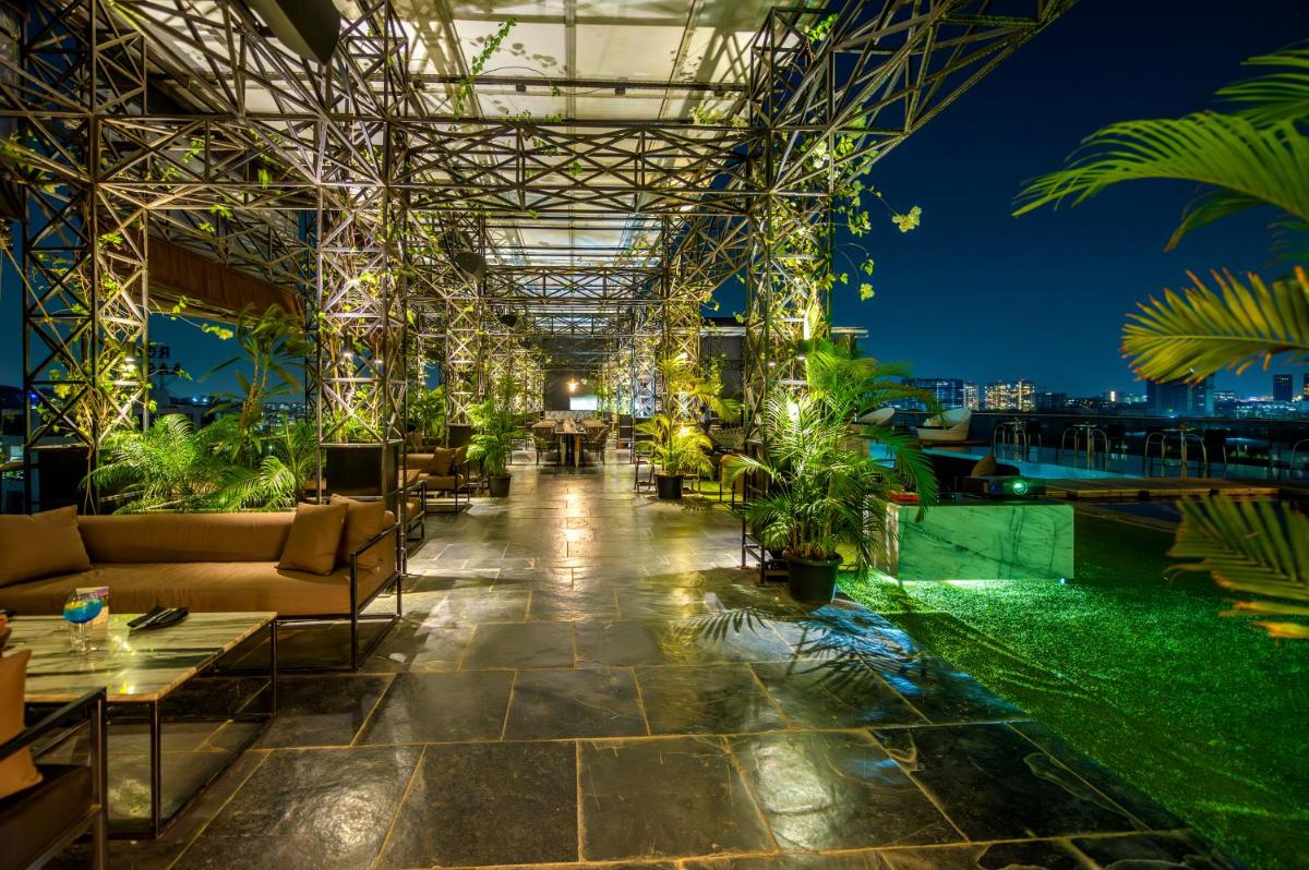 a lobby of a building with couches and plants at O Hotel Pune in Pune