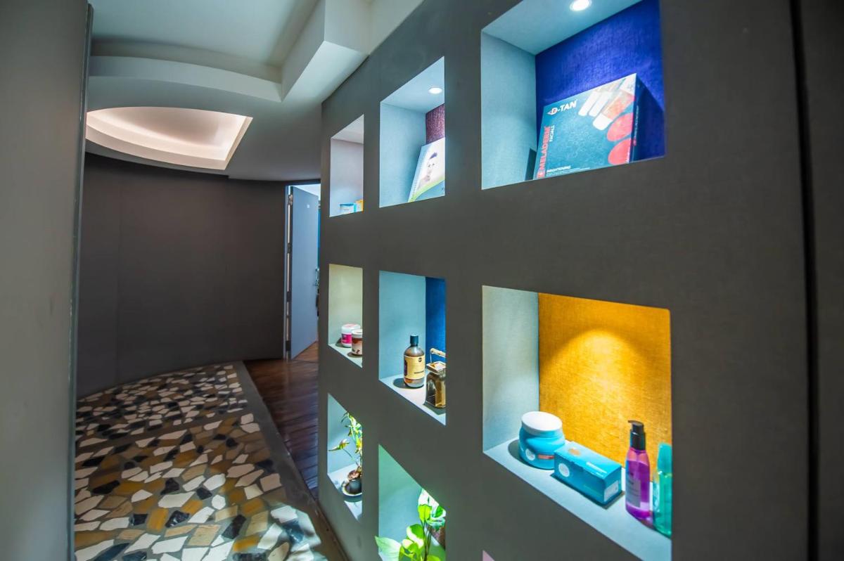 a hallway with a bathroom with a wall with shelves at O Hotel Pune in Pune
