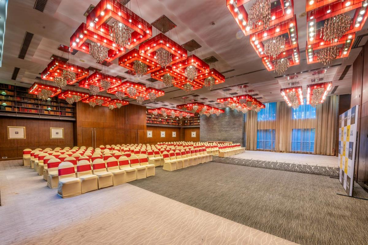 an empty banquet hall with red chandeliers and chairs at O Hotel Pune in Pune +112 photos
