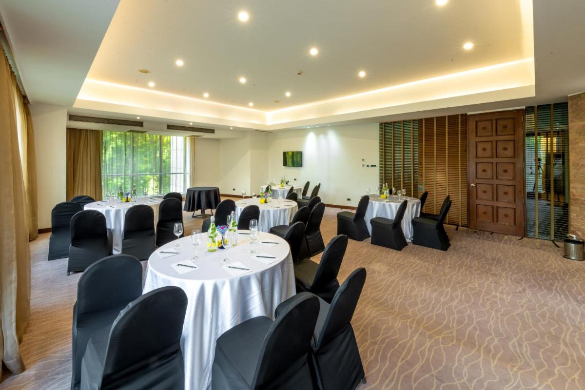 a conference room with tables and chairs in a room at O Hotel Pune in Pune