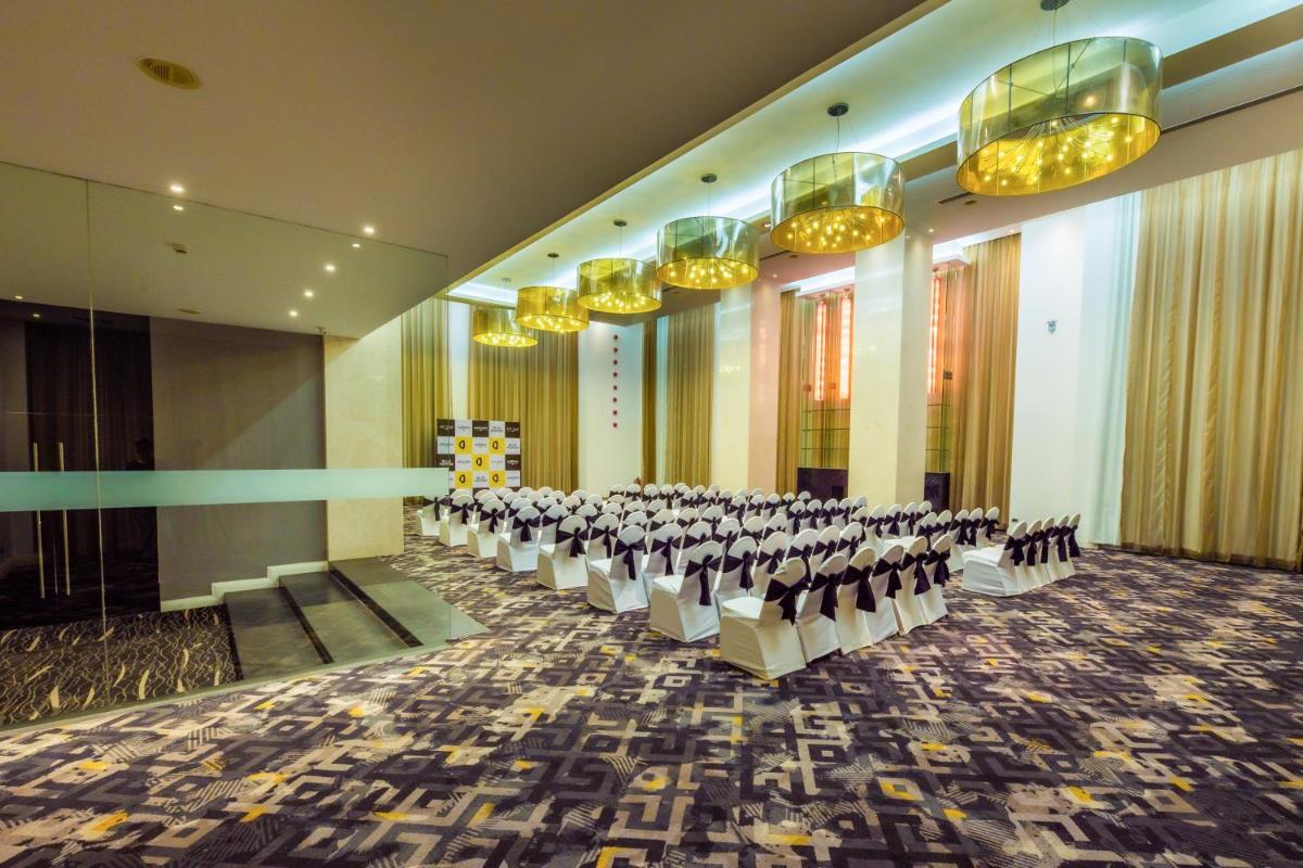 a conference room with rows of chairs and chandeliers at O Hotel Pune in Pune