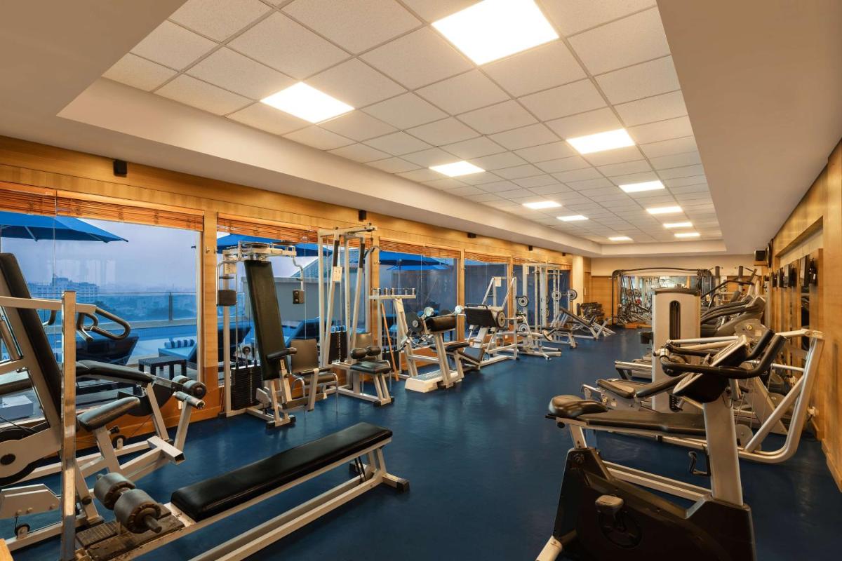 a gym with rows of treadmills and machines at Radisson Jaipur City Center in Jaipur