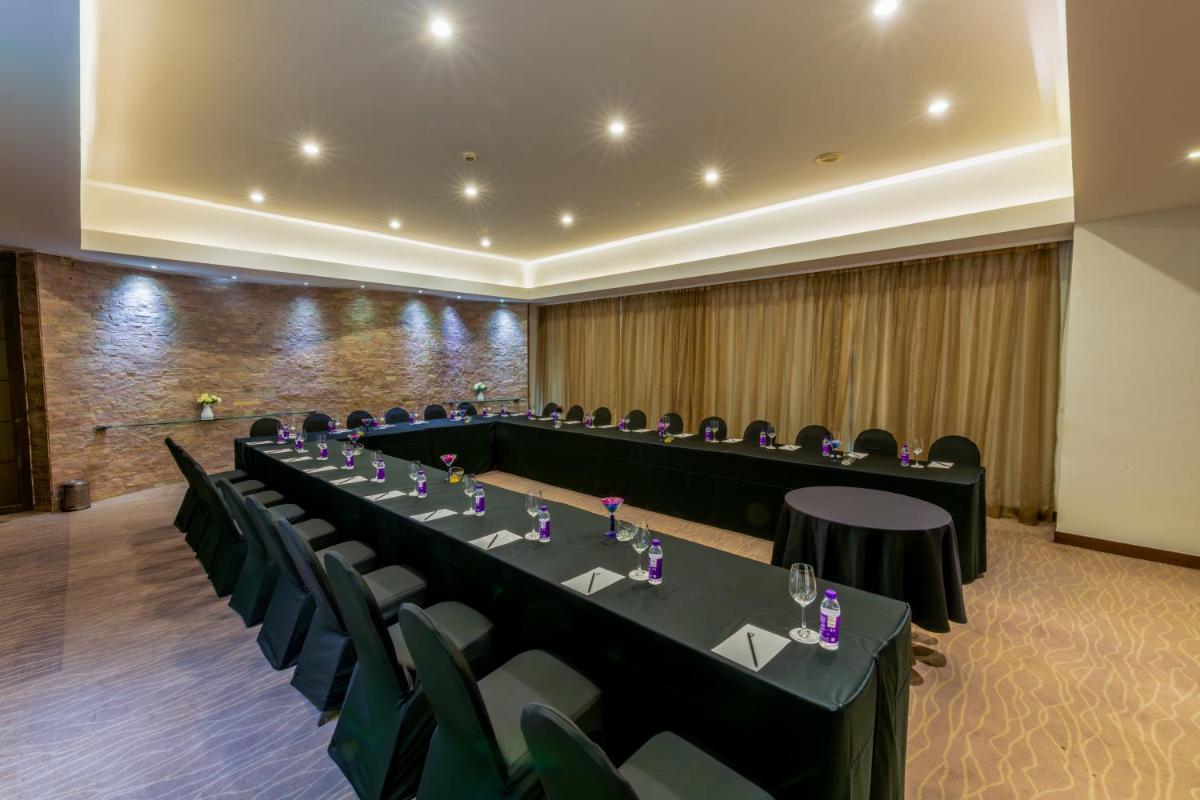 a conference room with long tables and chairs at O Hotel Pune in Pune