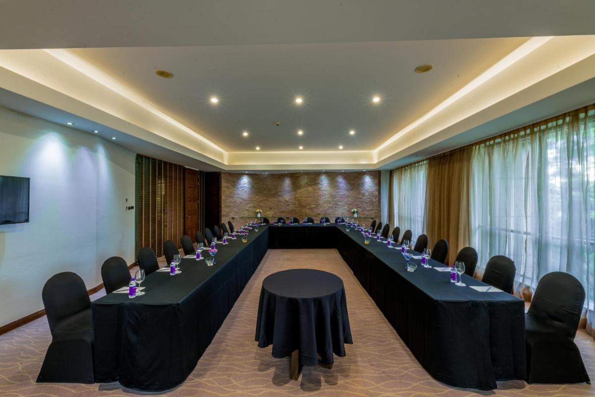 a conference room with long tables and chairs in it at O Hotel Pune in Pune