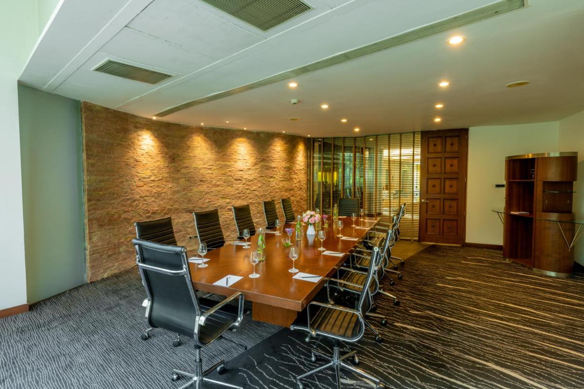 a conference room with a long table and chairs at O Hotel Pune in Pune