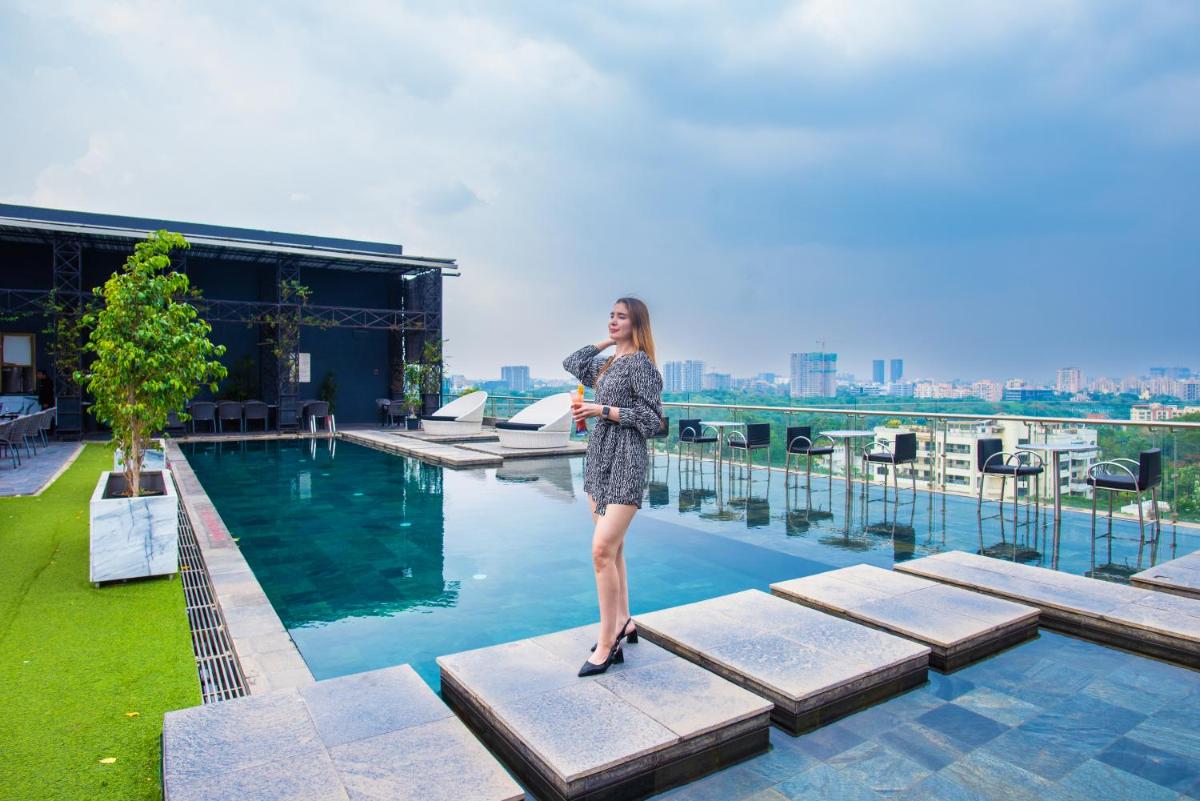 a woman standing on the steps of a swimming pool at O Hotel Pune in Pune