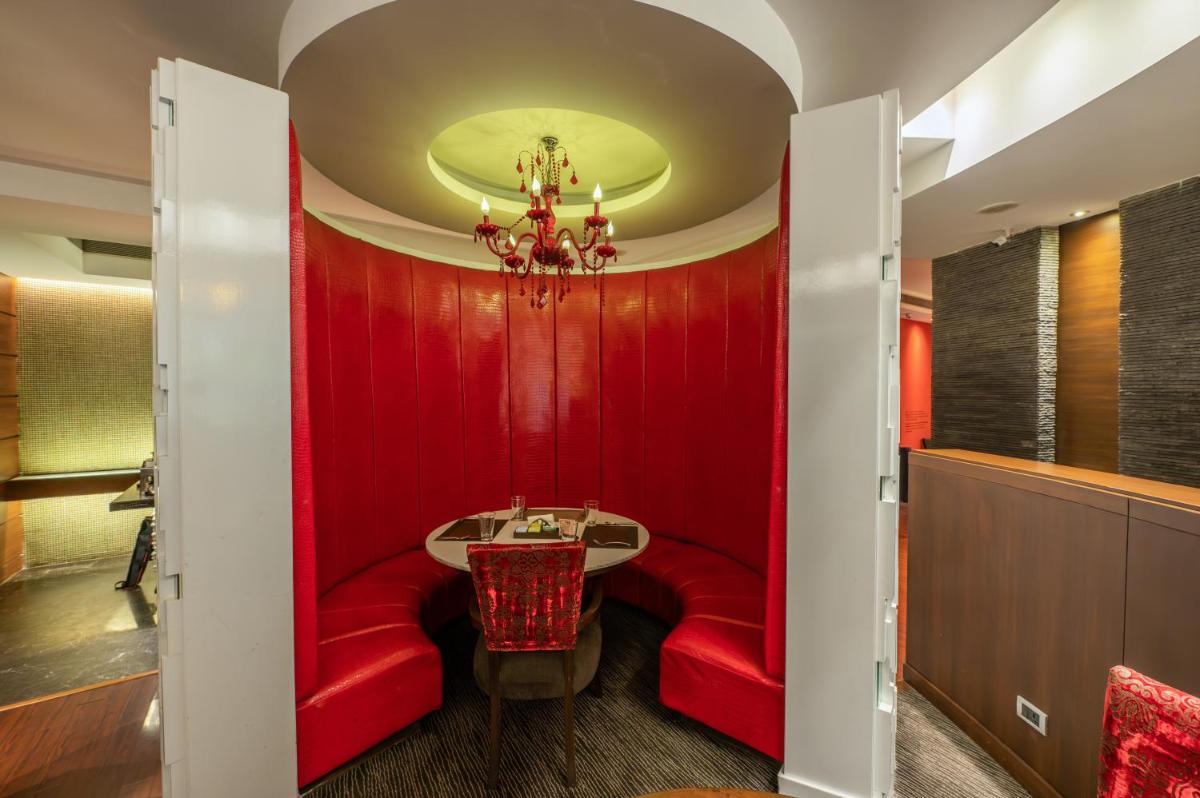 a red room with a table and a red wall at O Hotel Pune in Pune