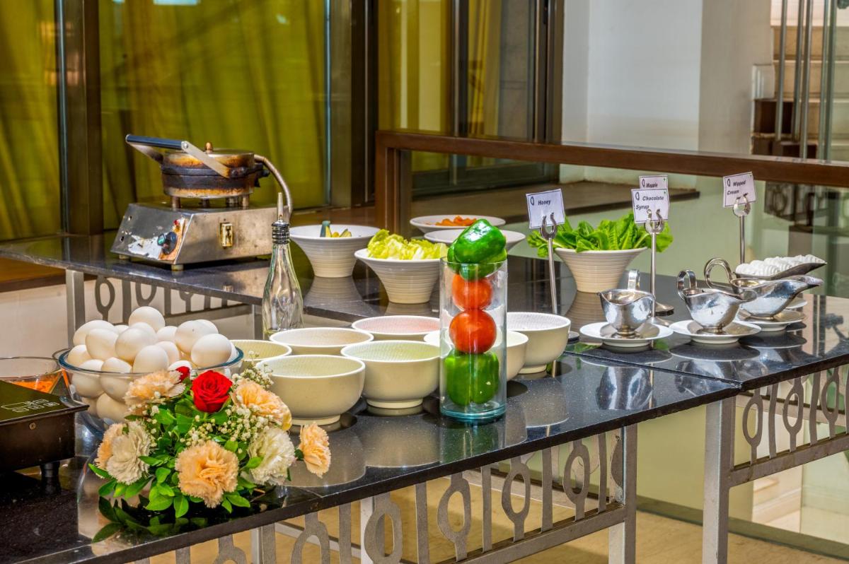 a buffet with bowls and dishes on a table at O Hotel Pune in Pune