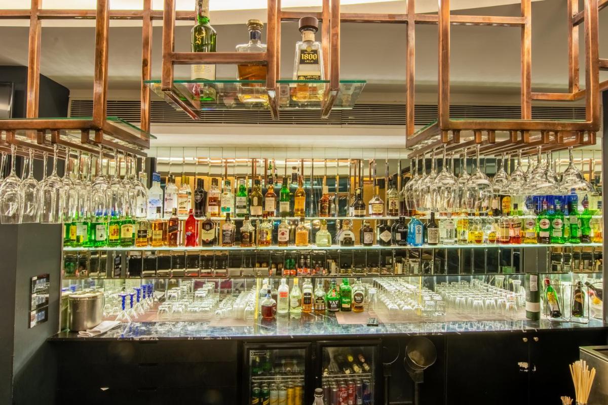 a bar with a lot of bottles of alcohol at O Hotel Pune in Pune