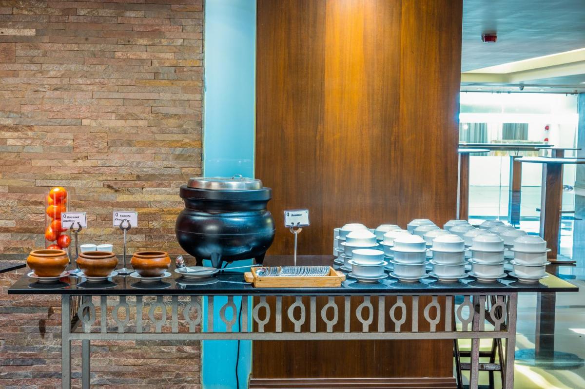 a table with a bunch of bowls and plates on it at O Hotel Pune in Pune