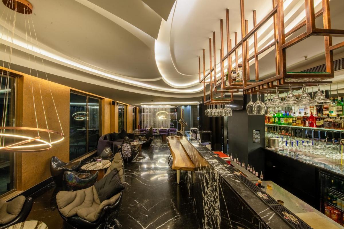 a bar with couches and tables in a restaurant at O Hotel Pune in Pune