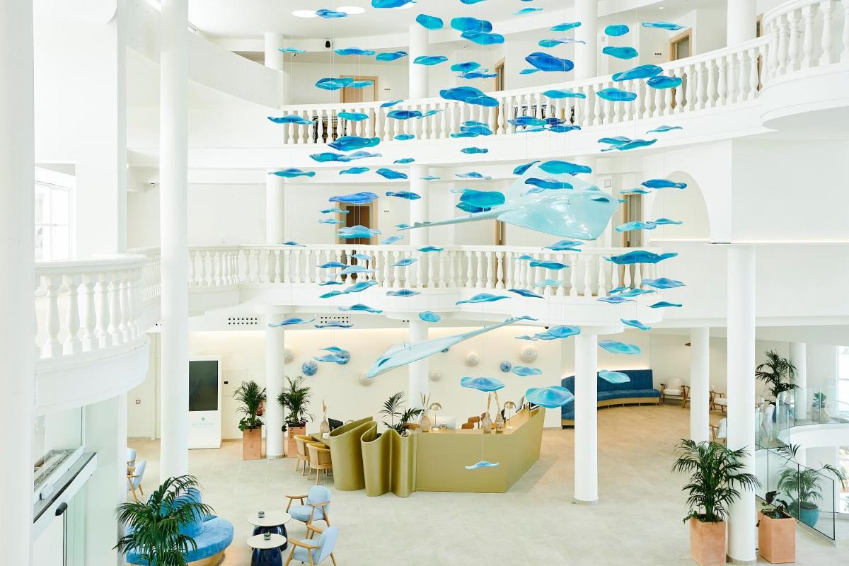 Una habitación con sombrillas azules colgando del techo. en Iberostar Selection Albufera Playa All Inclusive, en Playa de Muro
