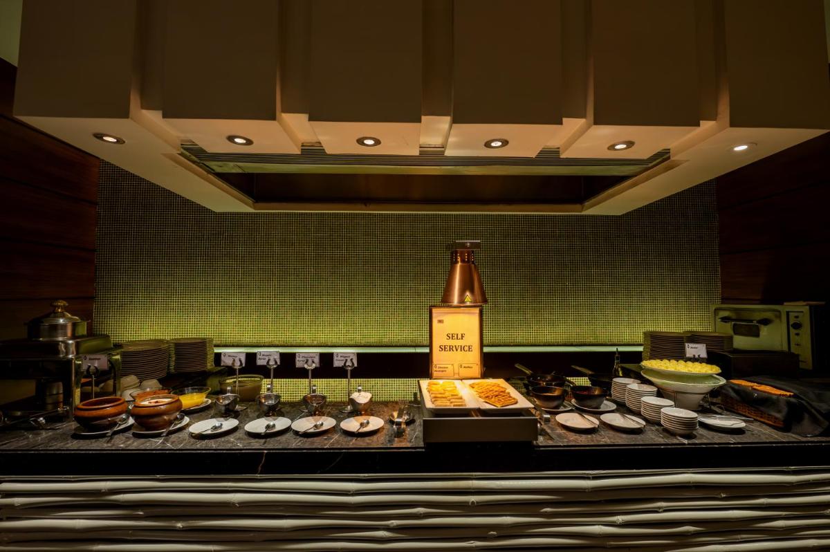a kitchen with a counter with food on it at O Hotel Pune in Pune