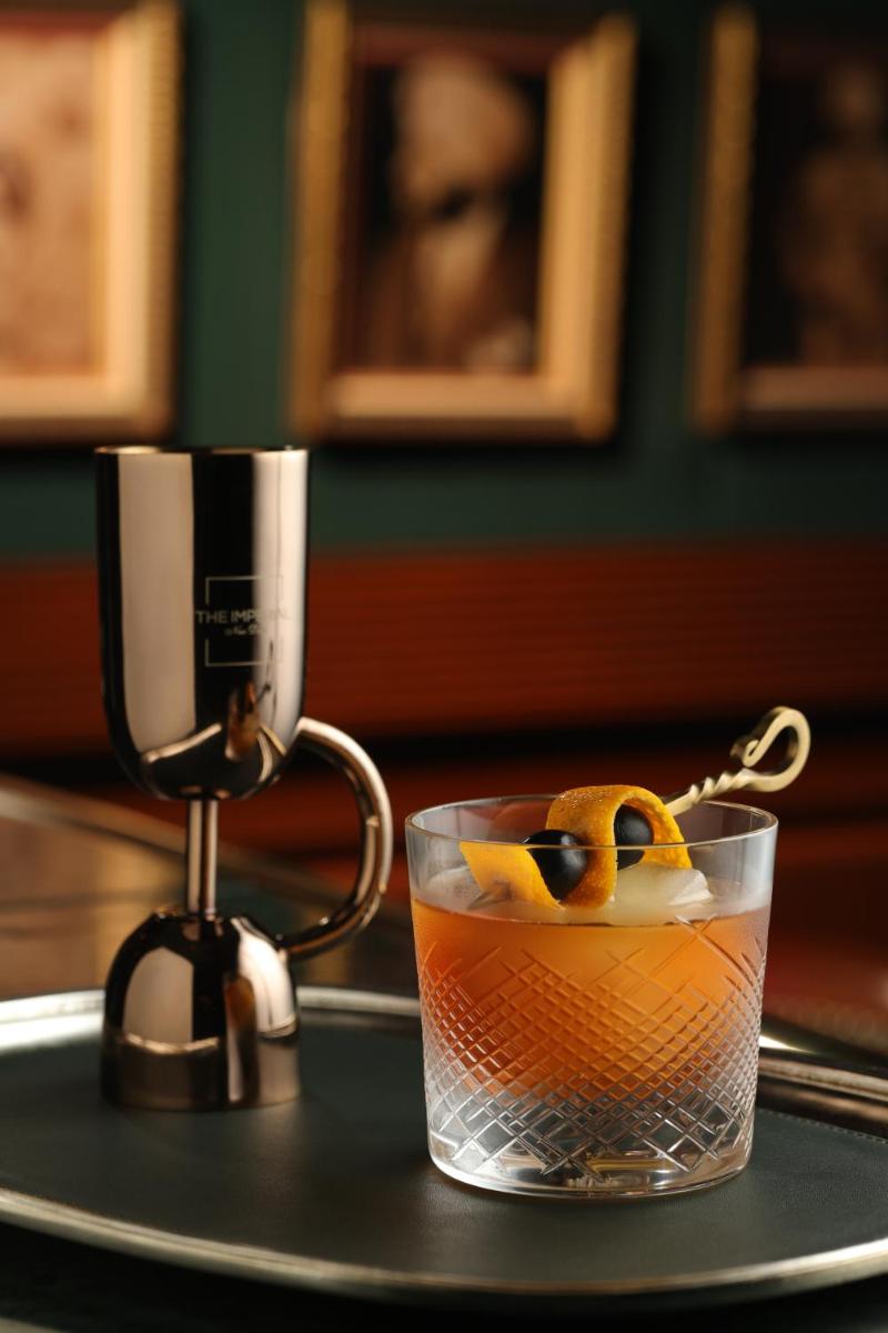 a drink in a glass on a table with a juicer at The Imperial, New Delhi in New Delhi a drink in a glass on a table with a juicer at The Imperial, New Delhi in New Delhi