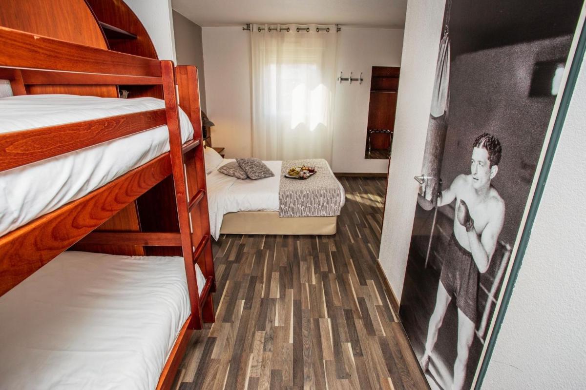 Un ou plusieurs lits dans un hébergement de l'établissement Sporting House Hôtel