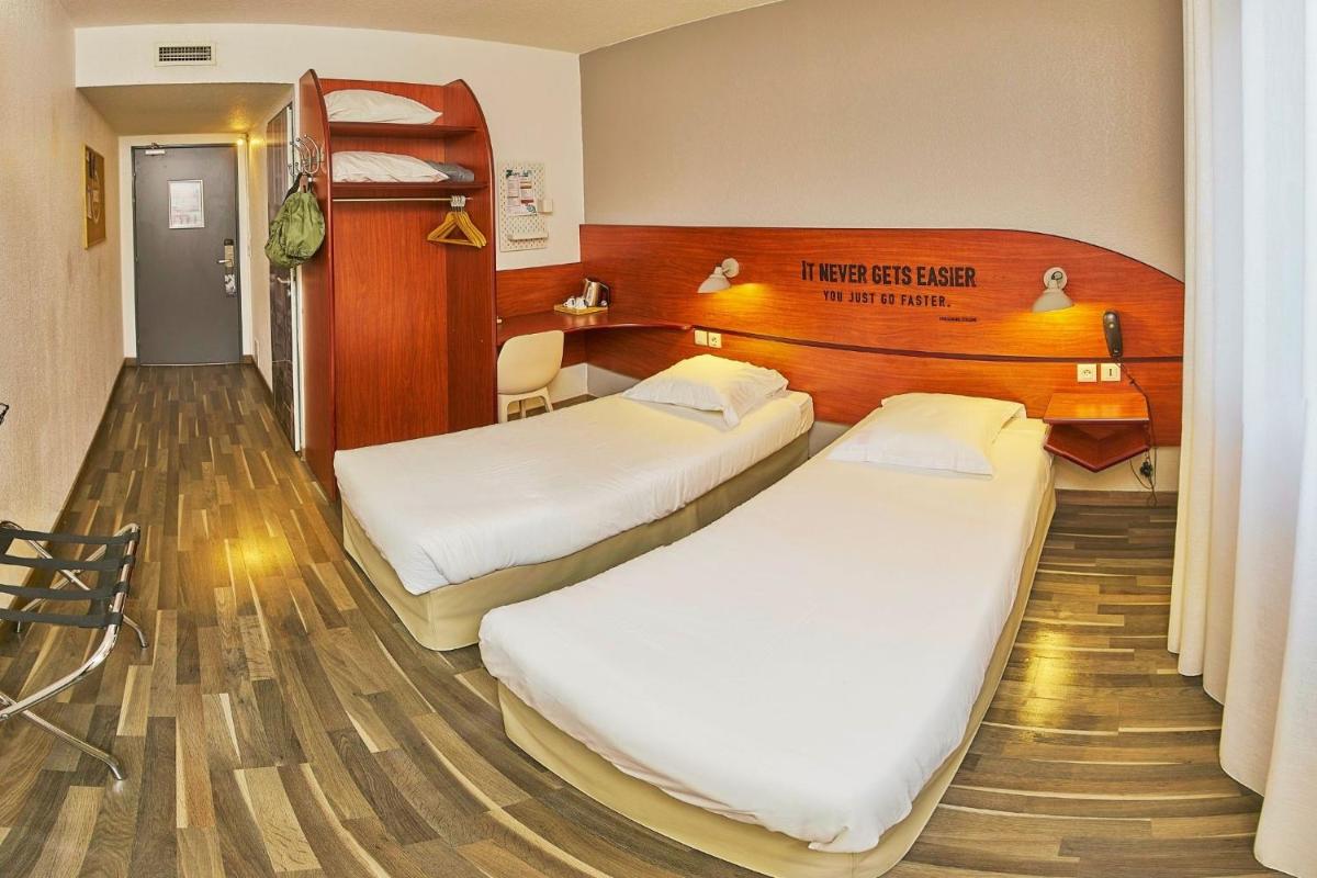 Un ou plusieurs lits dans un hébergement de l'établissement Sporting House Hôtel