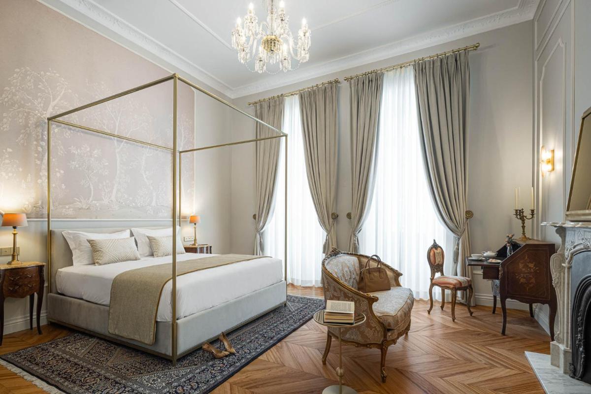 um quarto com uma cama e um lustre em MS Collection Aveiro - Palacete Valdemouro em Aveiro