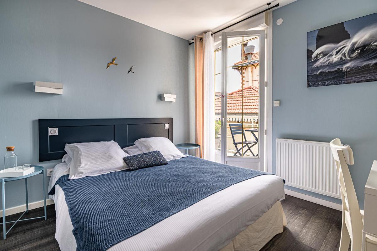 une chambre avec un grand lit et une fenêtre dans l'établissement Hôtel de charme & SPA Le Grand Large, à La Bernerie-en-Retz