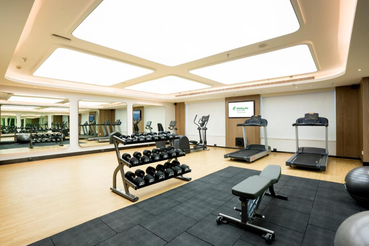 a gym with lots of treadmills and exercise equipment at Holiday Inn Lucknow Airport by IHG in Lucknow