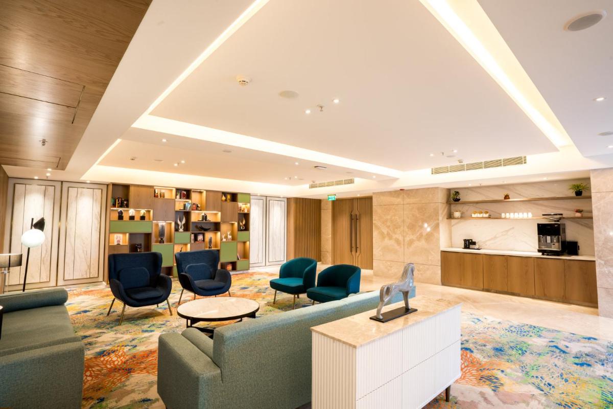 a living room with a couch and chairs and a table at Holiday Inn Lucknow Airport by IHG in Lucknow