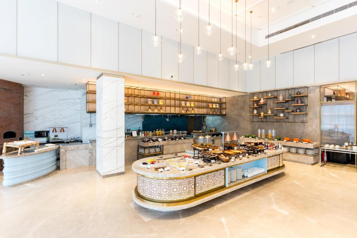 a large kitchen with a buffet in a restaurant at Holiday Inn Lucknow Airport by IHG in Lucknow