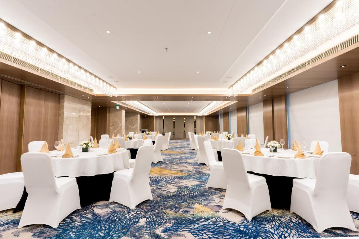 a conference room with white tables and white chairs at Holiday Inn Lucknow Airport by IHG in Lucknow