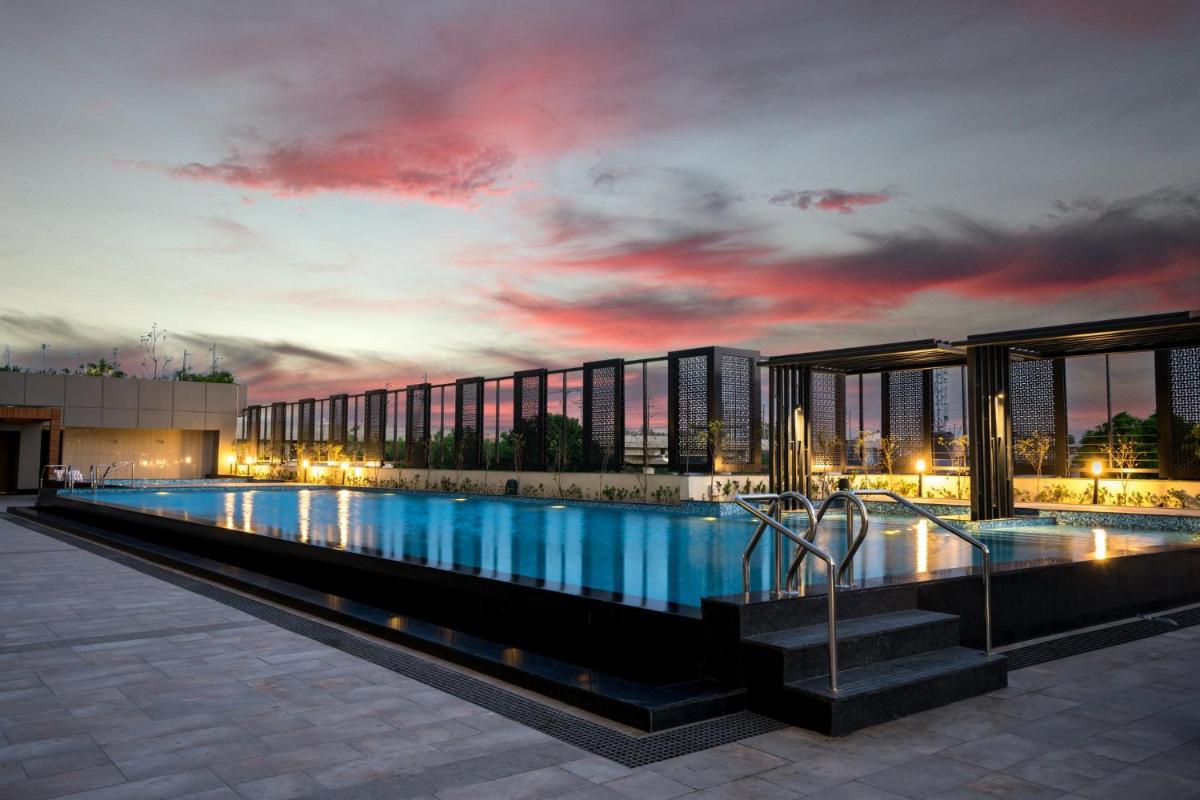 a large swimming pool in front of a building at Holiday Inn Lucknow Airport by IHG in Lucknow