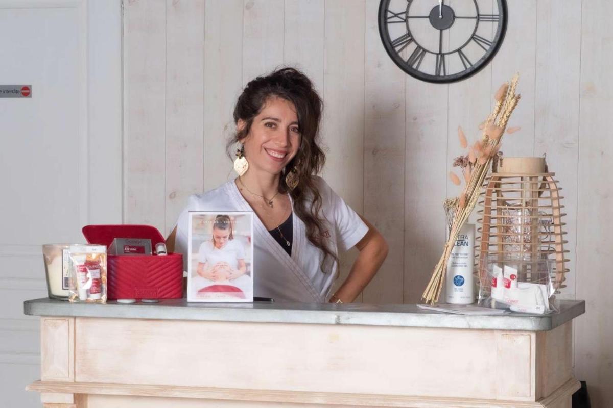 une femme debout derrière un comptoir avec une photo d'un bébé dans l'établissement Elégance Suites Hôtel, au Bois-Plage-en-Ré 47 autres photos