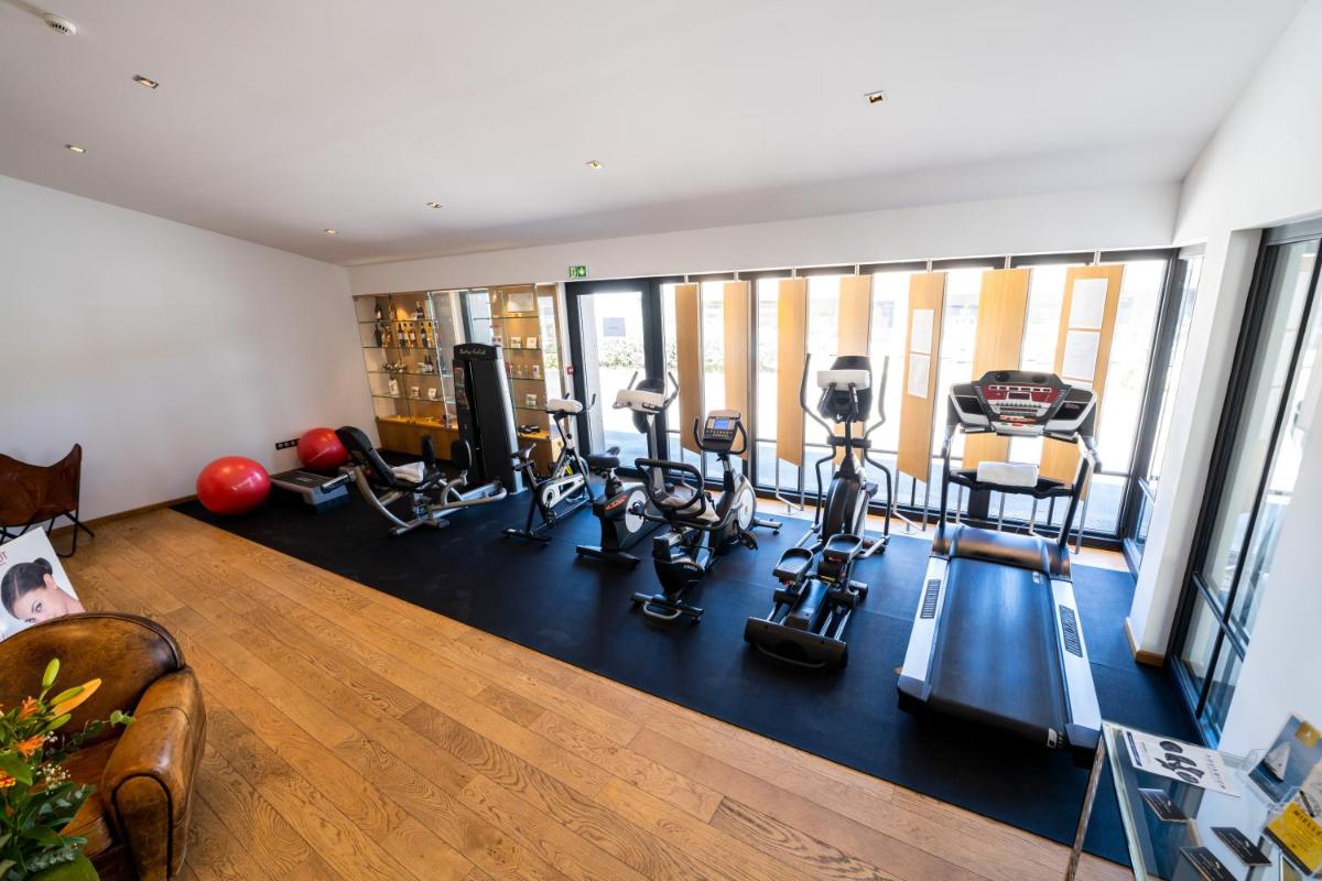 une image d'une salle de sport avec tapis de course et elliptiques dans l'établissement Elégance Suites Hôtel, au Bois-Plage-en-Ré
