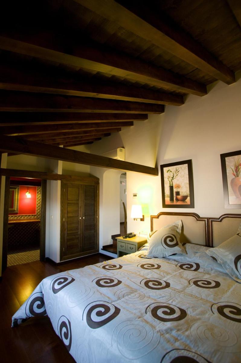 Un dormitorio con una cama grande en una habitación. en Hotel Spa La Casa Del Convento, en Chinchón