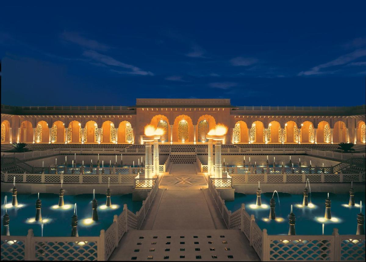 a building with a pool of water at night at The Oberoi Amarvilas Agra in Agra