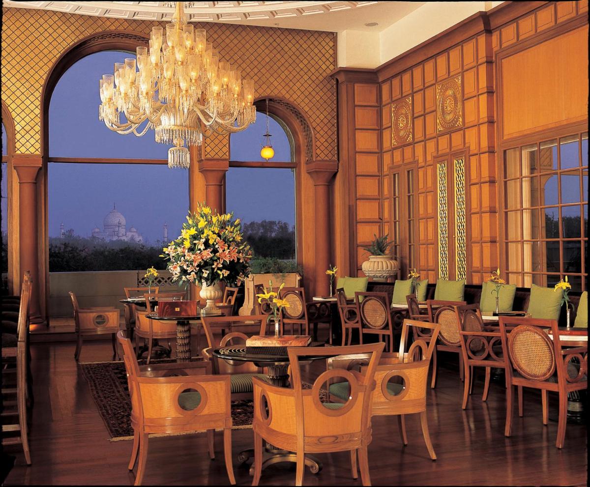 a dining room with tables and chairs and a chandelier at The Oberoi Amarvilas Agra in Agra