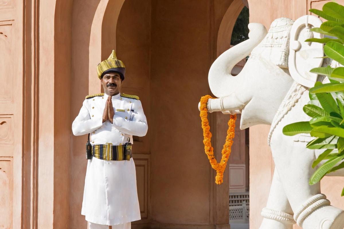 a man in a military uniform standing next to a statue at The Oberoi Amarvilas Agra in Agra
