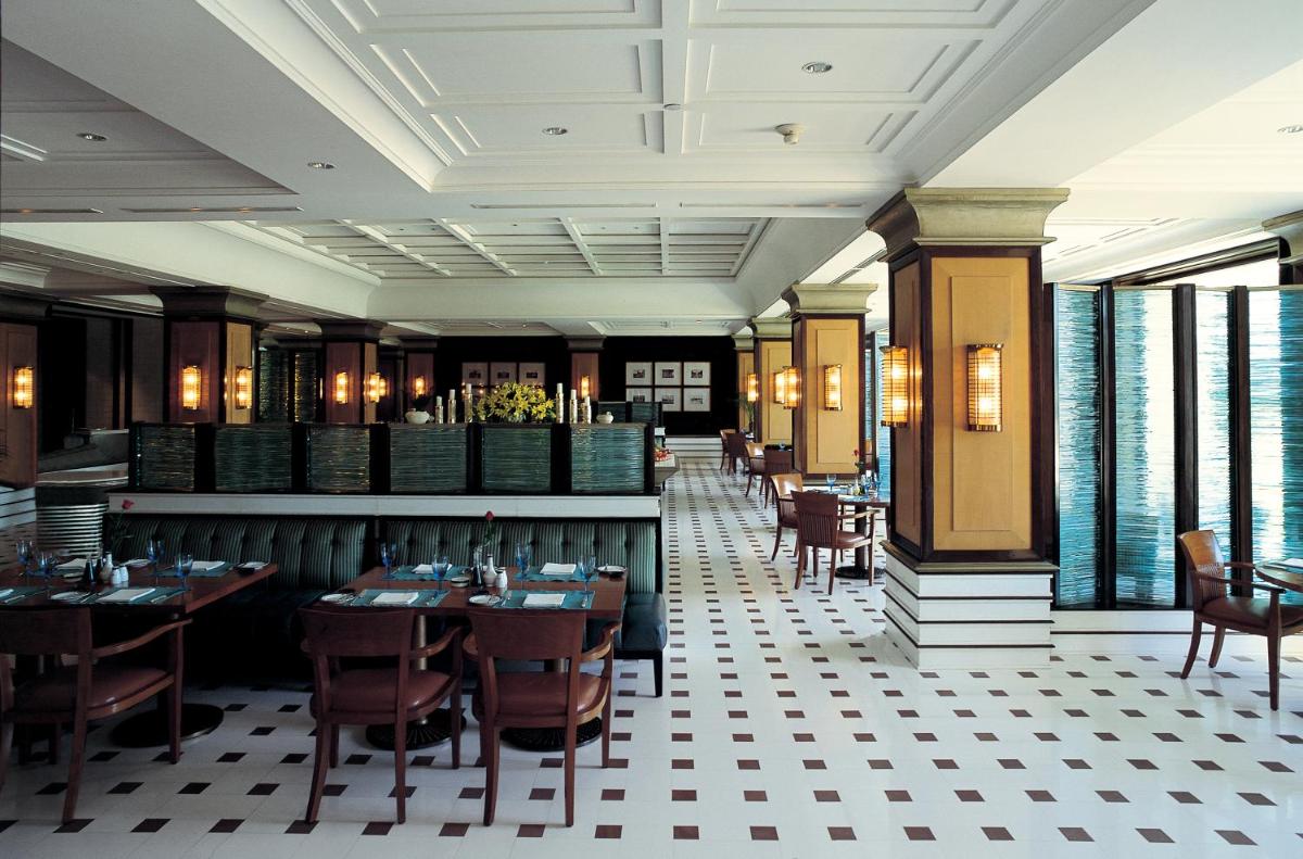 a dining room with tables and chairs and windows at The Oberoi Amarvilas Agra in Agra
