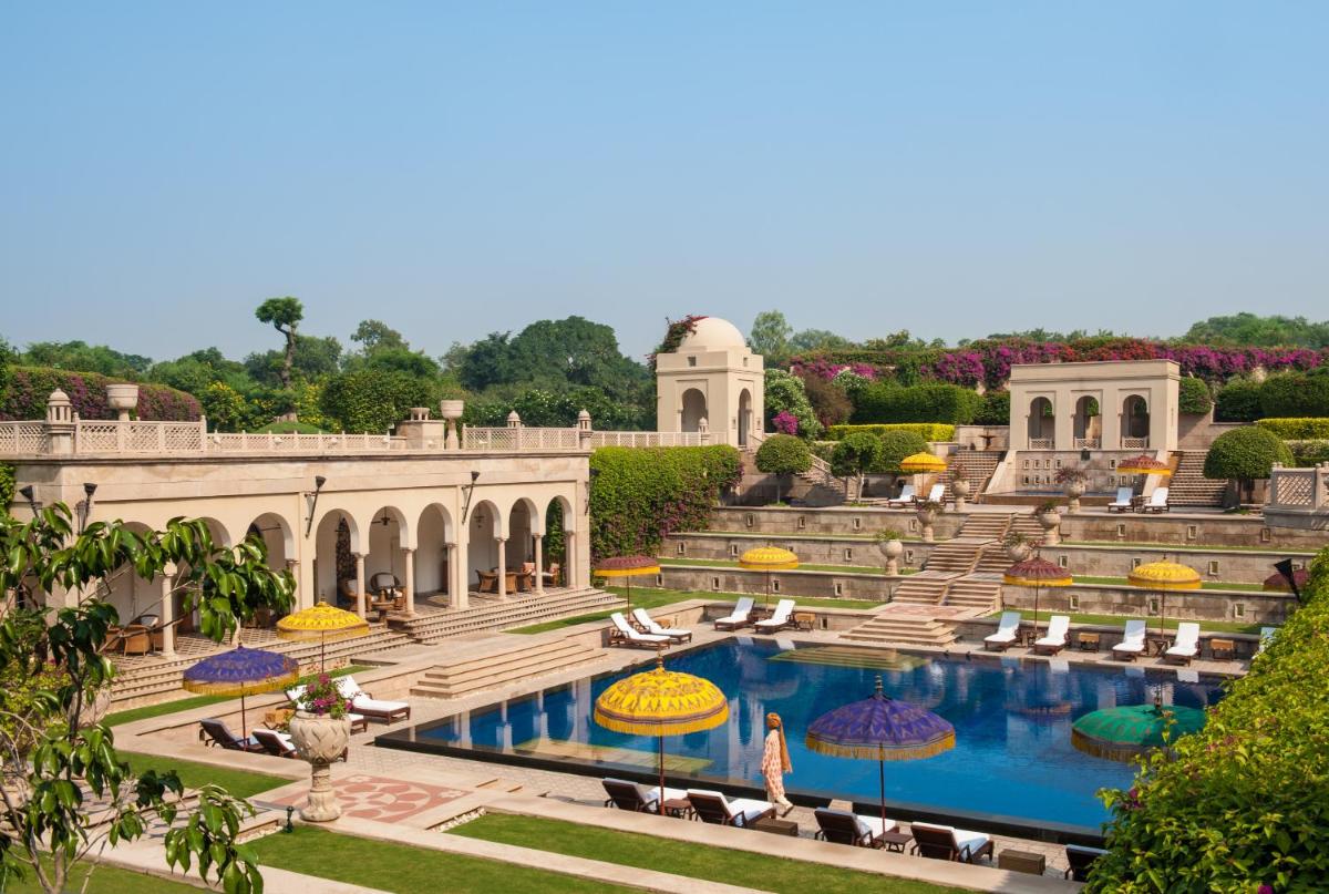 a resort with a swimming pool and umbrellas at The Oberoi Amarvilas Agra in Agra