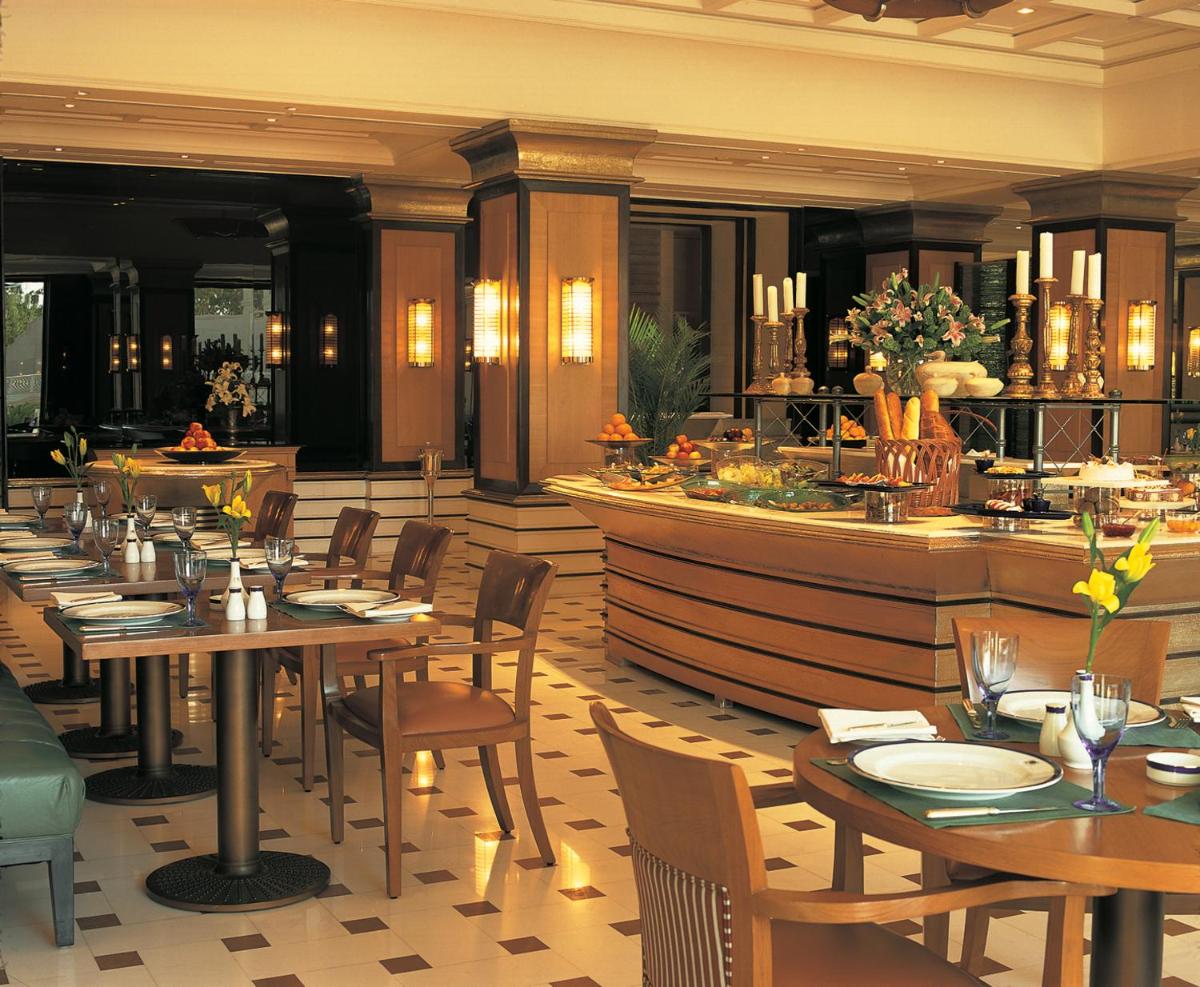 a restaurant with tables and chairs and a bar at The Oberoi Amarvilas Agra in Agra