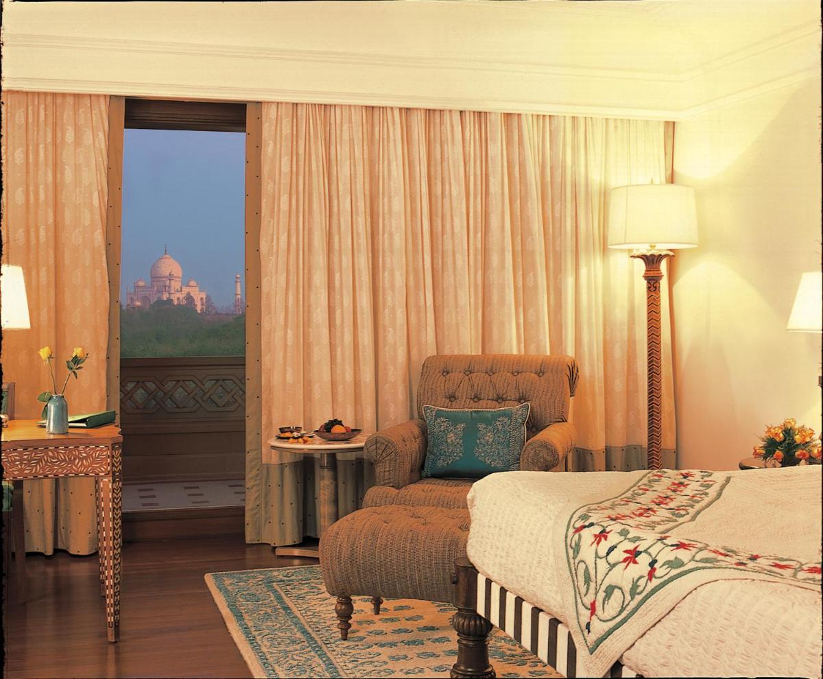 a bedroom with a bed and a chair and a window at The Oberoi Amarvilas Agra in Agra