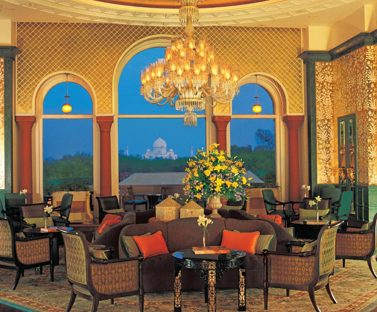 a lobby with a couch and chairs and a chandelier at The Oberoi Amarvilas Agra in Agra