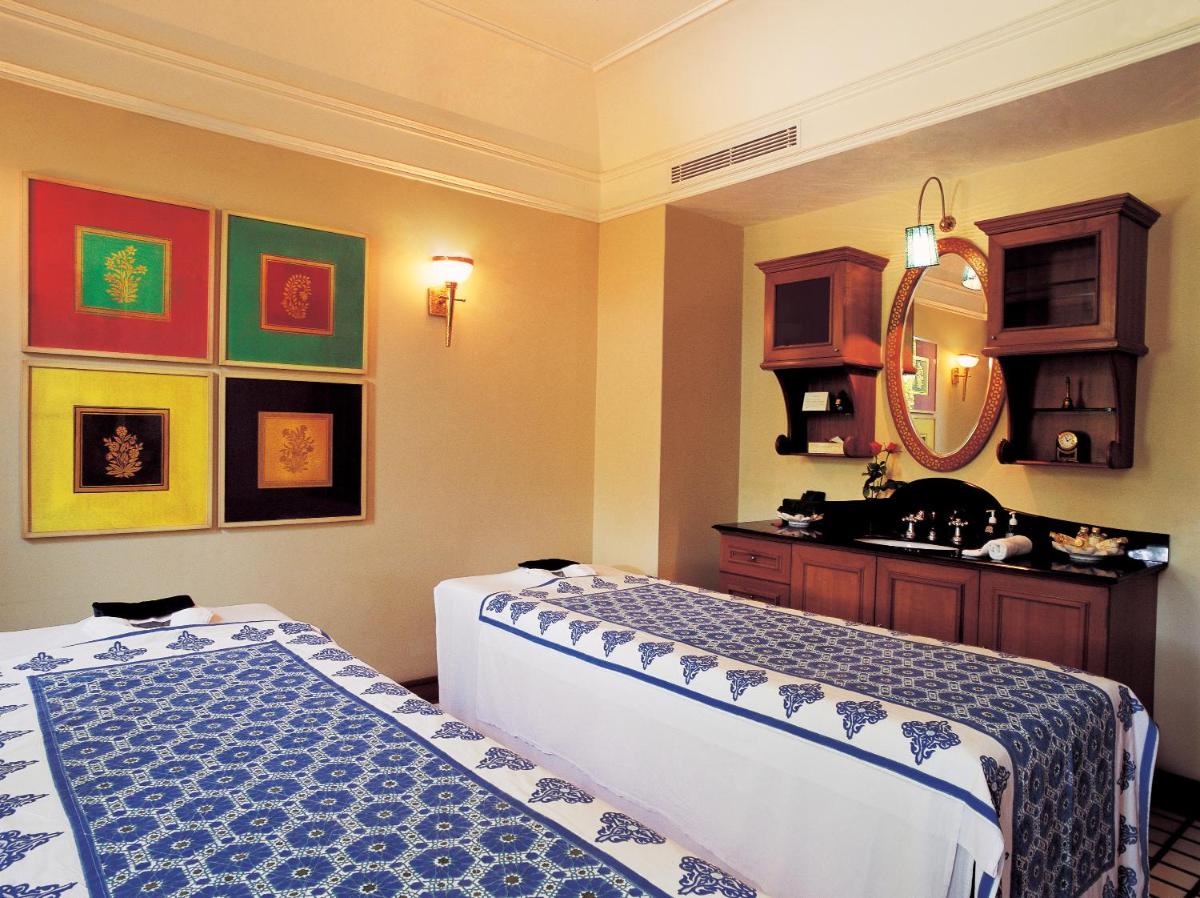 a hotel room with two beds and a mirror at The Oberoi Amarvilas Agra in Agra