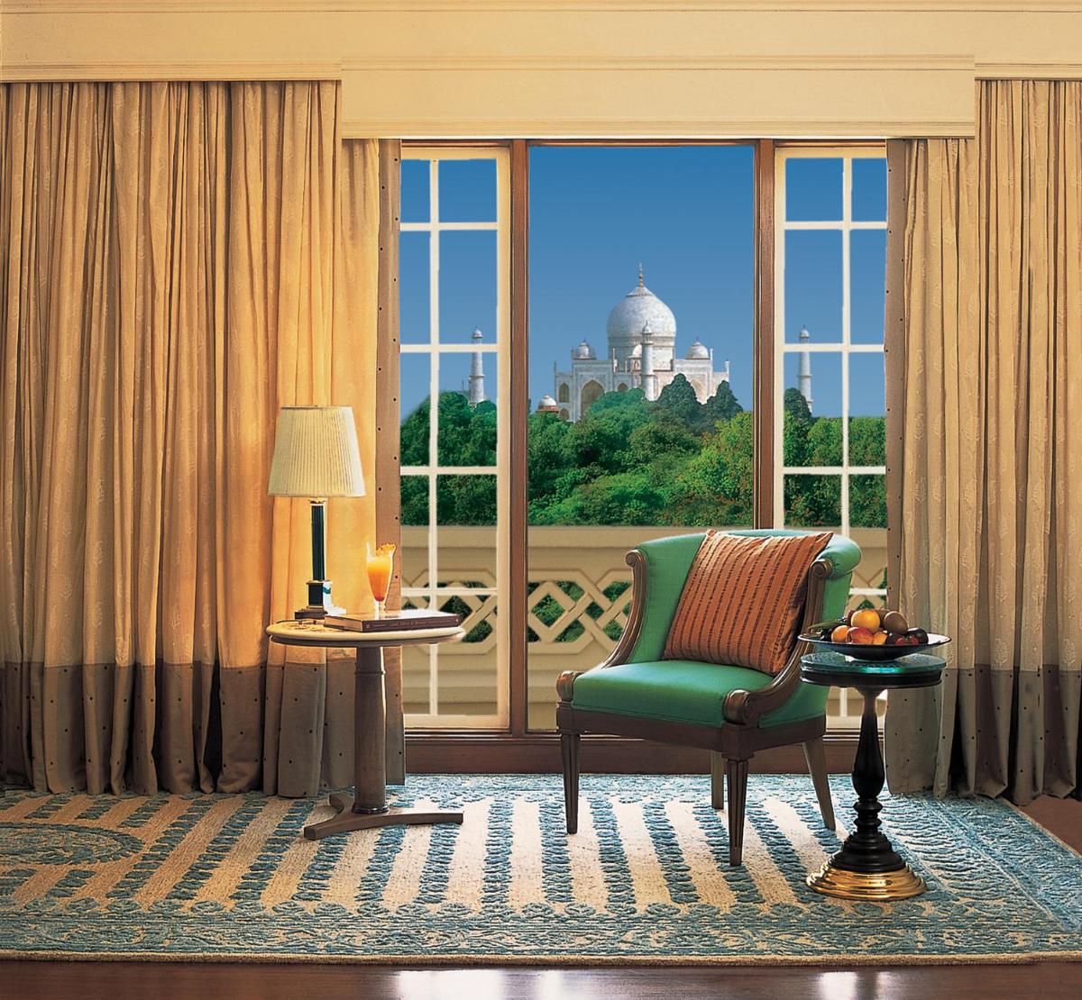 a living room with a green chair and a window at The Oberoi Amarvilas Agra in Agra
