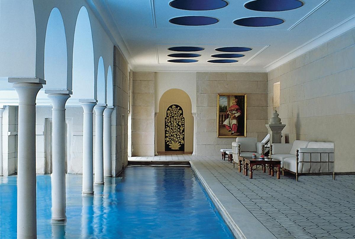 a pool in the lobby of a building with columns at The Oberoi Amarvilas Agra in Agra