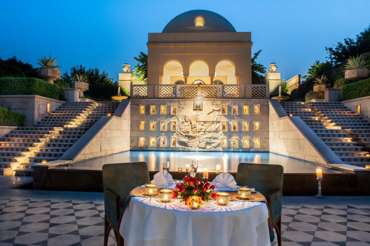 a table in front of a building with lights at The Oberoi Amarvilas Agra in Agra