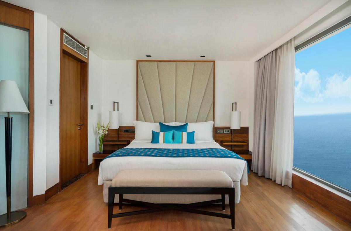 a bedroom with a bed with a view of the ocean at InterContinental Marine Drive Mumbai by IHG in Mumbai